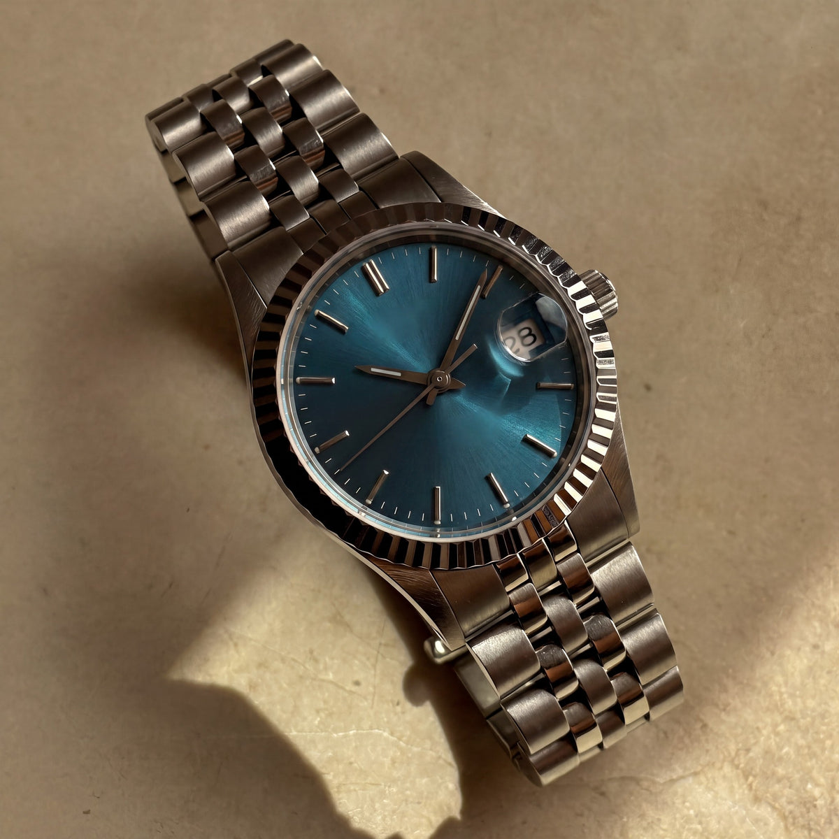 Trente-Neuf Bleu mer — vue de face, cadran bleu mer soleillé, lunette cannelée acier et bracelet cinq rangs — Maison Noirmont