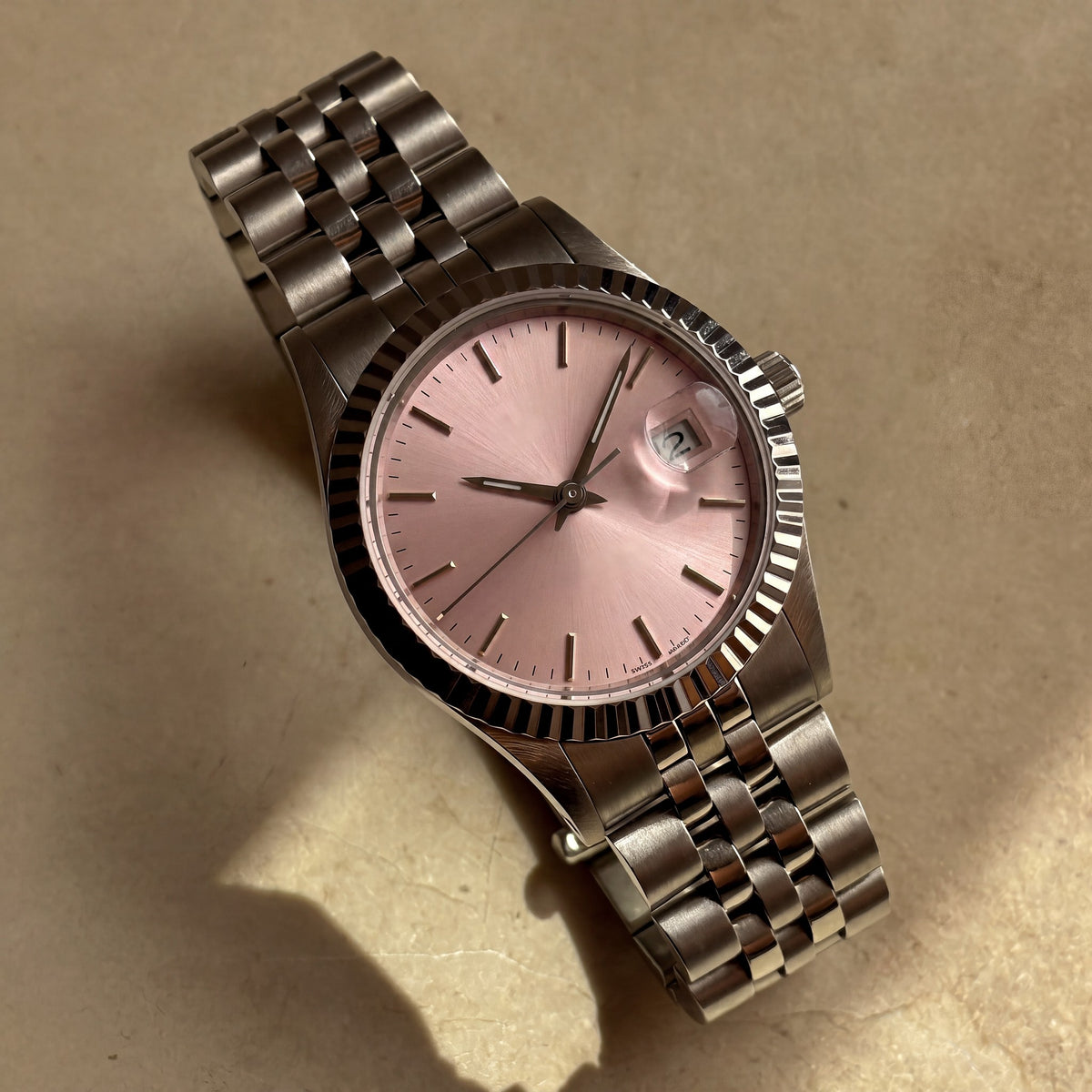 Trente-Neuf Rose — vue de face, cadran rose soleillé, lunette cannelée acier et bracelet cinq rangs — Maison Noirmont