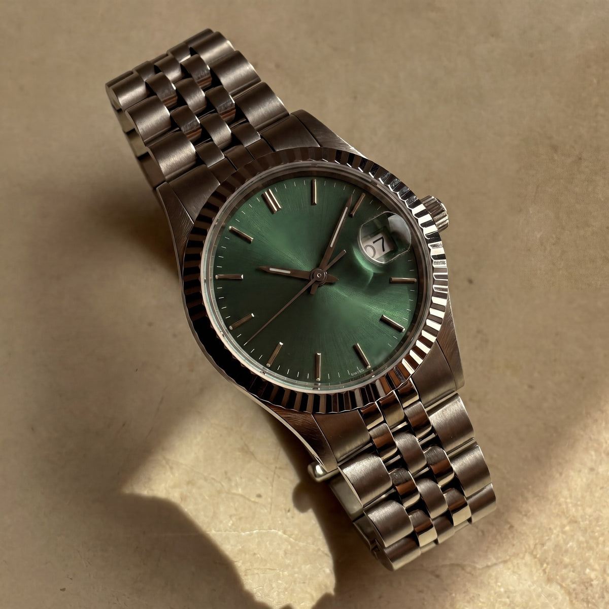 Trente-Neuf — cadran vert soleillé, index bâtons appliqués, lunette cannelée acier et bracelet cinq rangs — Maison Noirmont