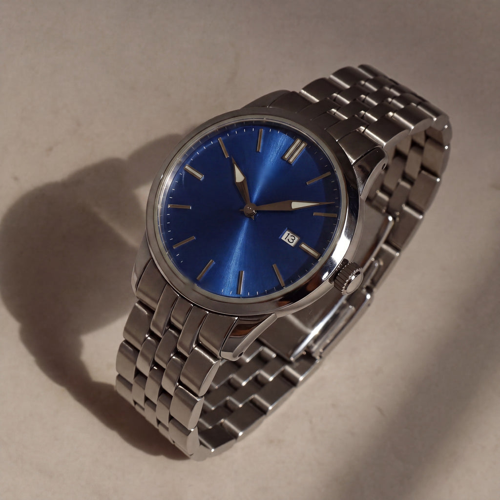 Trente-Six Bleu — vue de face, cadran bleu soleillé, index bâtons appliqués et bracelet cinq rangs acier — Maison Noirmont