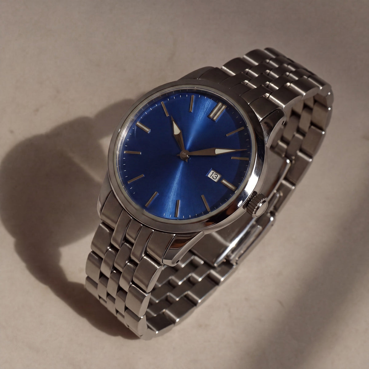 Trente-Six Bleu — vue de face, cadran bleu soleillé, index bâtons appliqués et bracelet cinq rangs acier — Maison Noirmont