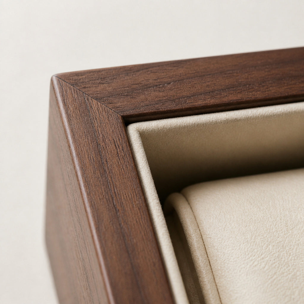 Coffret Douze présentation — macro de l'angle extérieur : coupe d'onglet du cadre en bois teinte noyer, doublure suédine crème et coussin de logement — Maison Noirmont