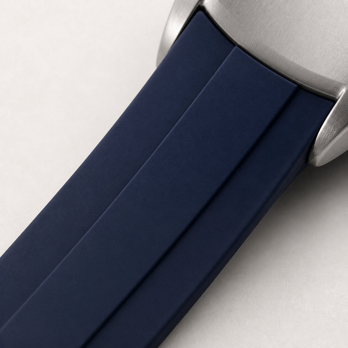 Contre-la-montre Compteurs bleus — détail du bracelet caoutchouc bleu marine et de sa jonction au boîtier acier — Maison Noirmont