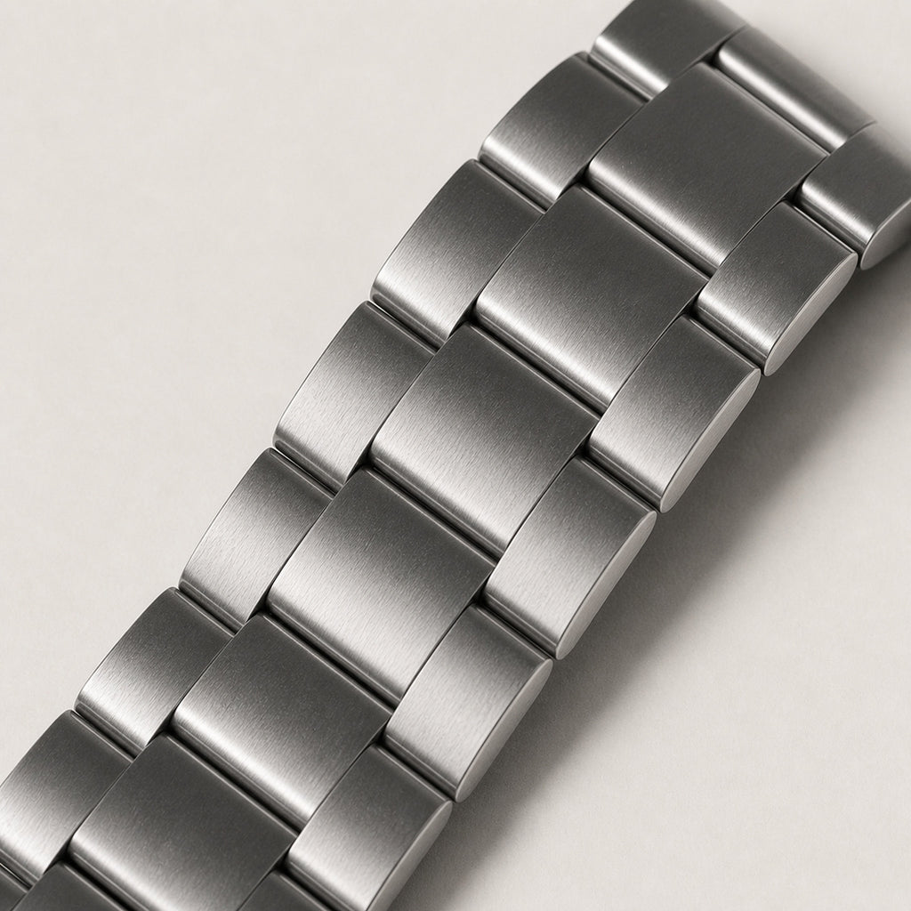 Héritage Vert — macro oblique du bracelet acier trois maillons entièrement brossé et de sa courbure — Maison Noirmont