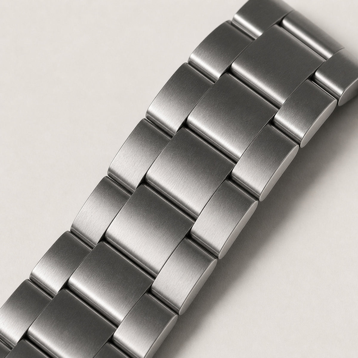 Héritage Vert — macro oblique du bracelet acier trois maillons entièrement brossé et de sa courbure — Maison Noirmont
