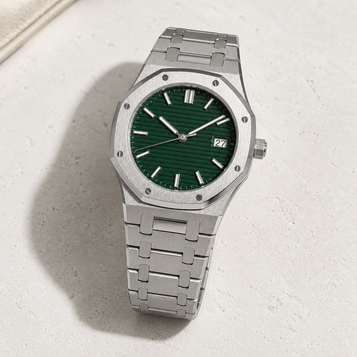 Intégrale Vert — montre à cadran vert texturé et bracelet acier intégré, posée de trois quarts sur fond clair — Maison Noirmont