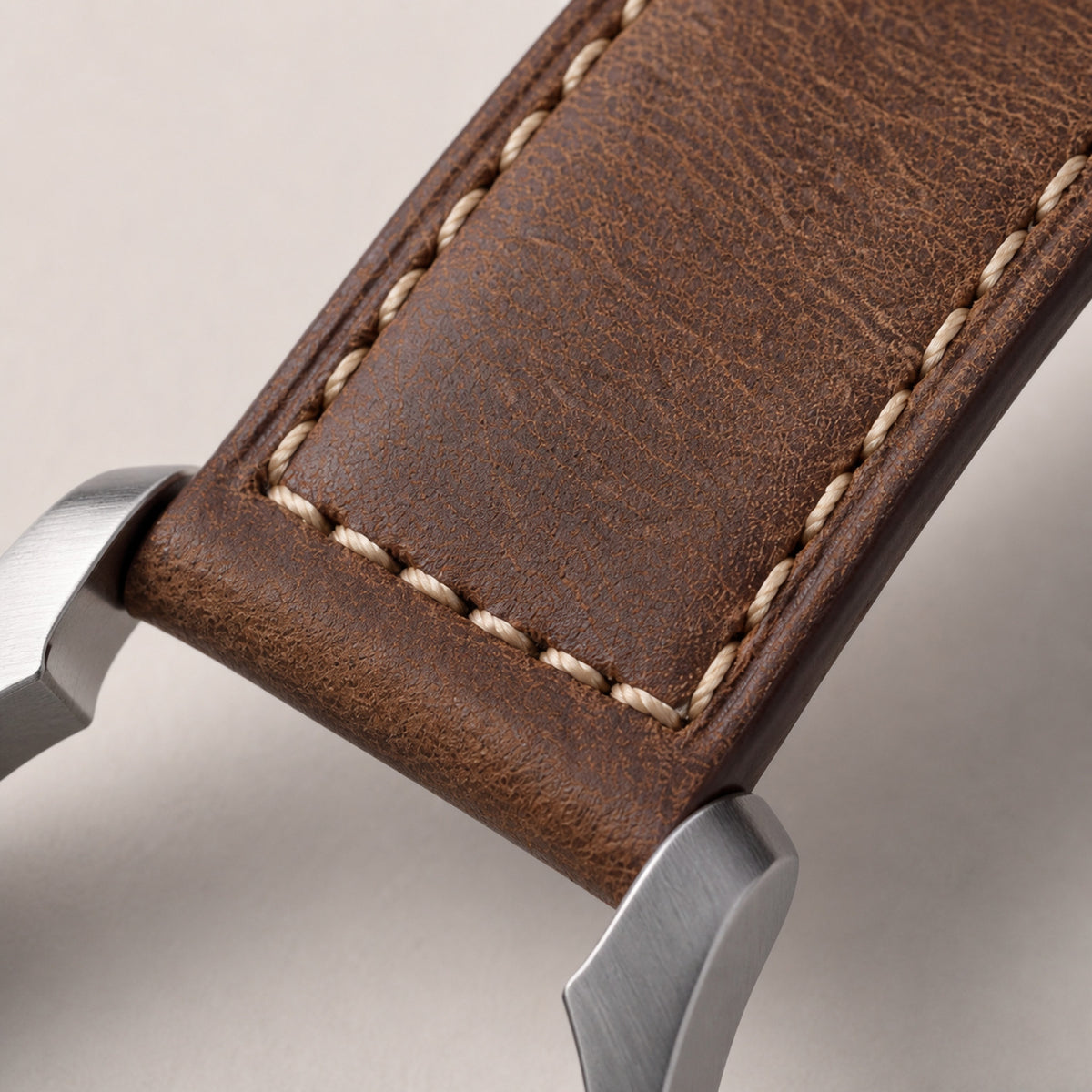 Noirmont Un — détail du bracelet cuir brun surpiqû écru et de la corne acier brossée — Maison Noirmont