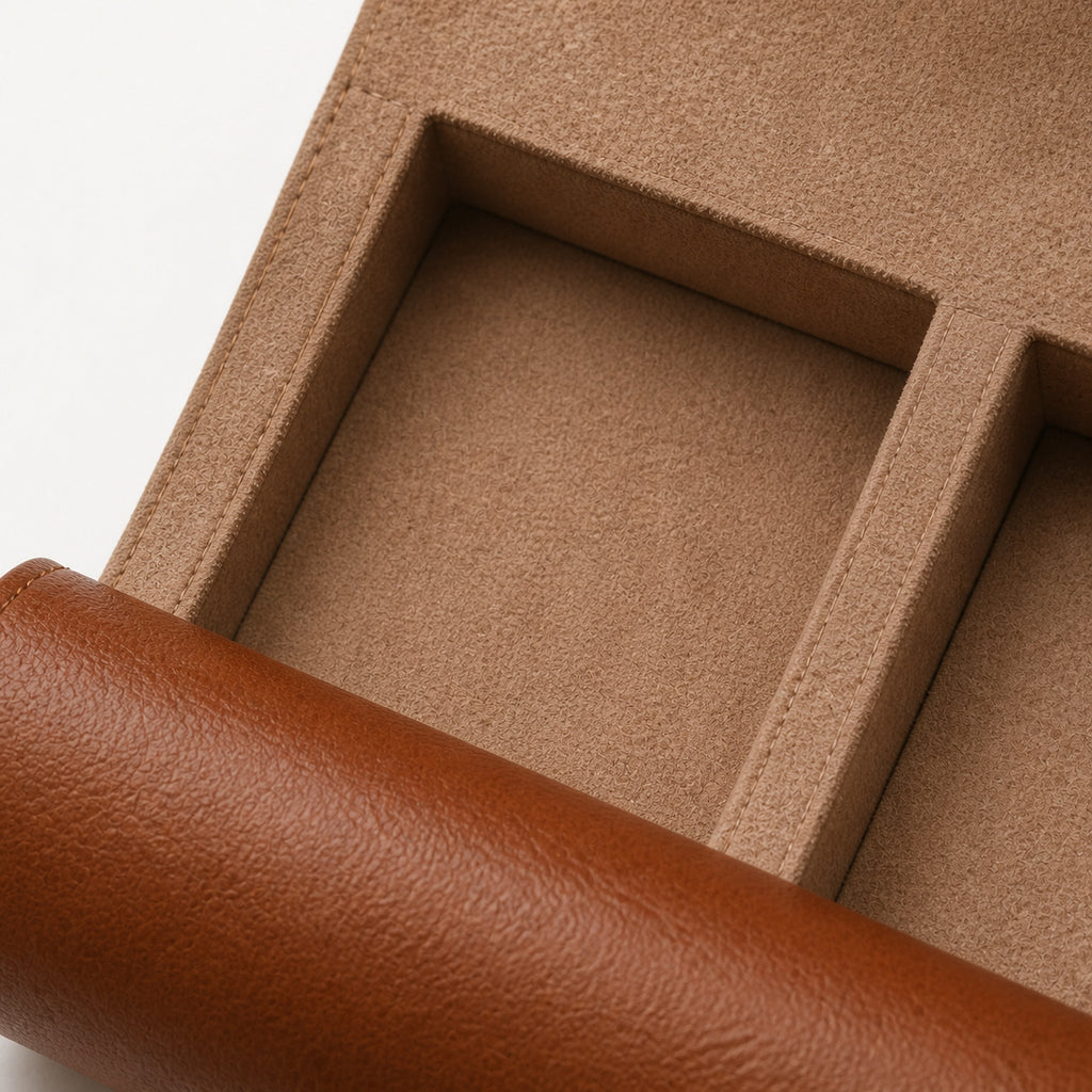 Rouleau de Voyage Brun — macro d'un logement intérieur : séparateurs et doublure en suédine taupe surpiquée, cuir extérieur cognac grainé roulé — Maison Noirmont