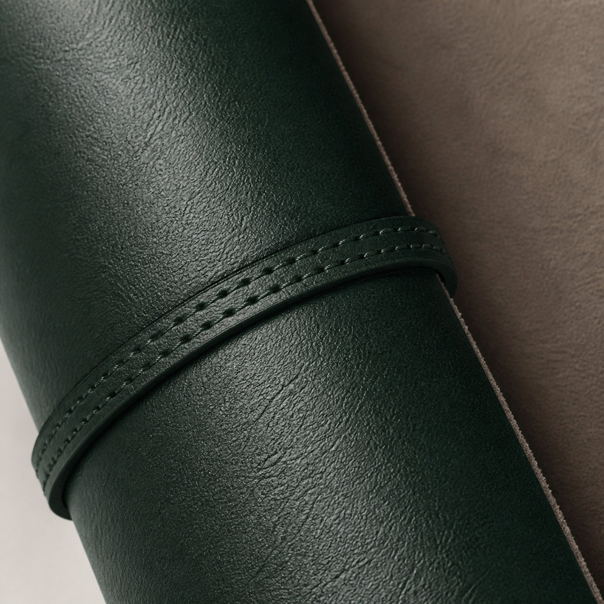 Rouleau de Voyage Vert — macro du cuir vert grainé et de la couture de la sangle de fermeture — Maison Noirmont